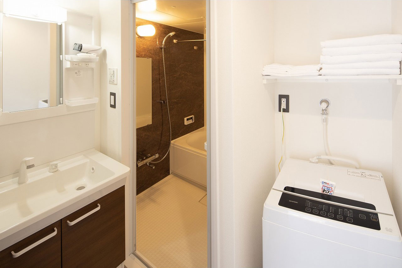 Coruscant Hotel客室リビングの写真。冷蔵庫やキッチン、電子レンジなどの生活家電付き。ダイニングテーブルとソファー有り。